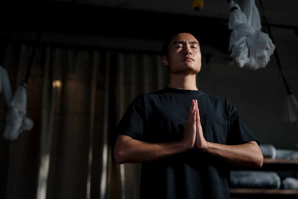 The Art of Drawing Readers In: Your attractive post title goes here An adult male practicing meditation in a yoga studio, focusing on mindfulness and wellbeing.